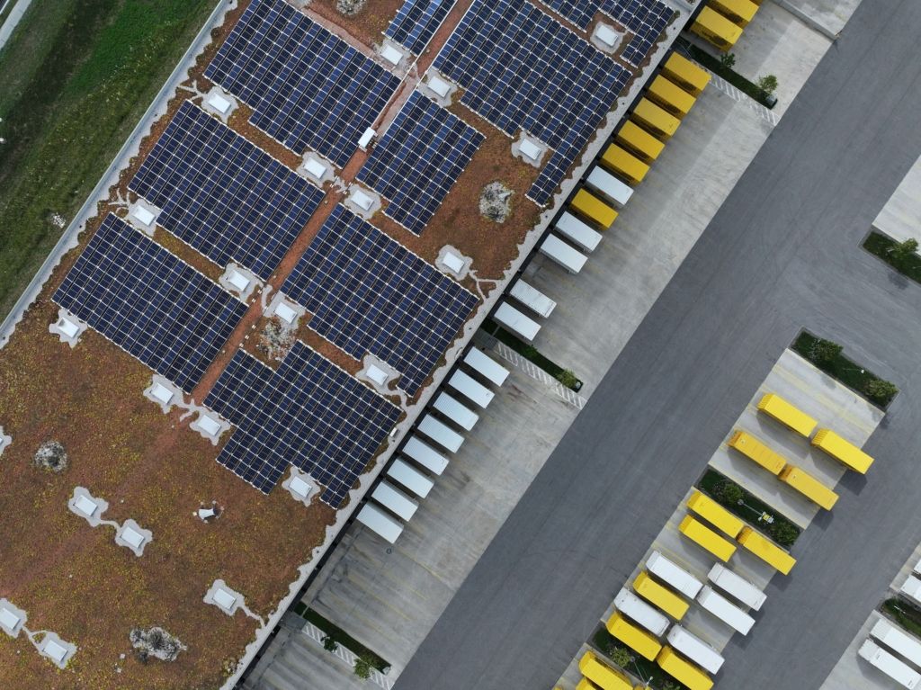 Luftaufnahme des Dachs des Post-Verteilerzentrums in Vomp, welches mit Solarpanels versehen und begrünt ist.