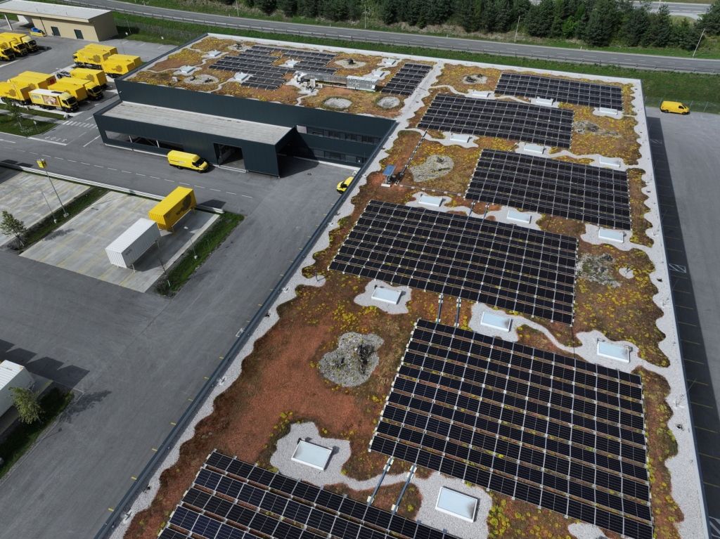 VOMP, AUSTRIA - JUNE 24: In this aerial view solar panels and a garden of locally-native succulents, stonecrop and other plants cover the rooftop of the main distribution center for the Austrian postal service in Tyrol as on June 24, 2023 in Vomp, Austria. The garden, which provides a habitat for local insects such as butterflies and beetles, is a pilot project called "Lebensraum Gruendach" ("Green Roof Habitat") led by the University of Innsbruck and supported by the Austrian federal government in an effort to gauge the effectiveness of using rooftops as locations for biodiversity enrichment. Biodiversity in Austria and across Europe is in steep decline due to decades of human intrusion in the forms of agriculture, water diversion, urban sprawl, construction and other activities that destroy natural habitats. Climate change is becoming an increasing threat, especially in Alpine regions, which are warming twice as fast as the global average. The European Parliament is currently considering the EU Nature Restoration Law that includes the aim of restoring natural habitats. (Photo by Sean Gallup/Getty Images)